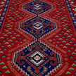 rug in deep red wool with triple diamond motif, demonstrating handwoven rug craftsmanship.