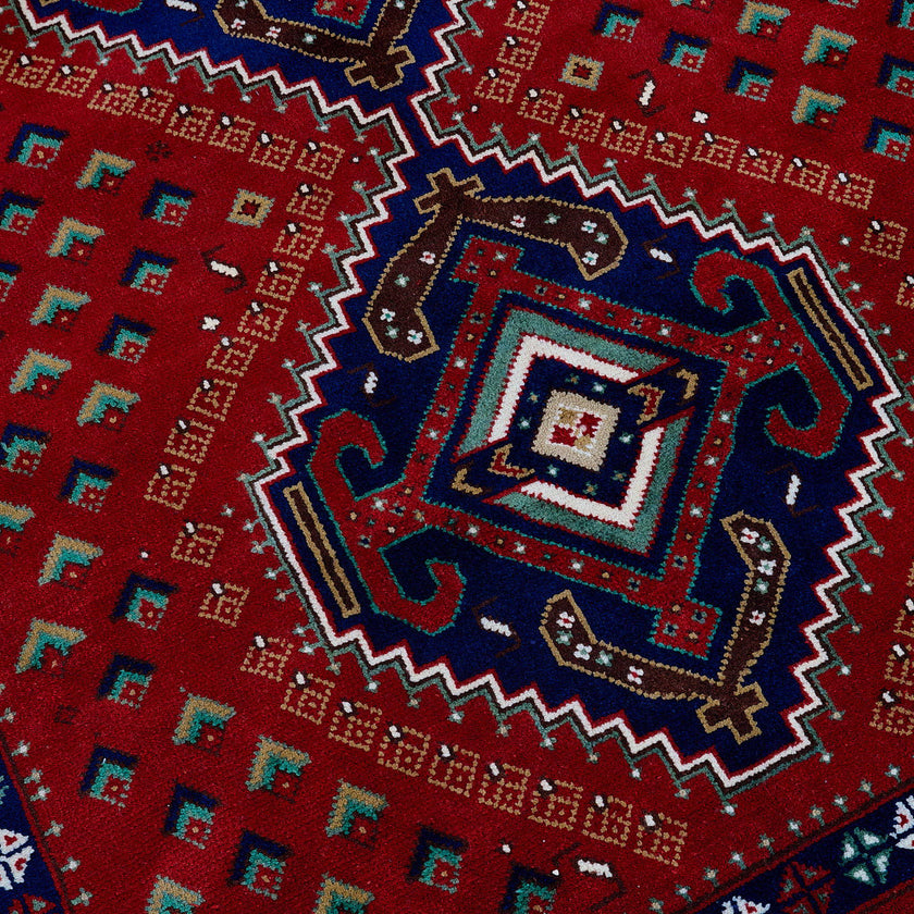 rug in deep red wool with triple diamond motif, demonstrating handwoven rug craftsmanship.