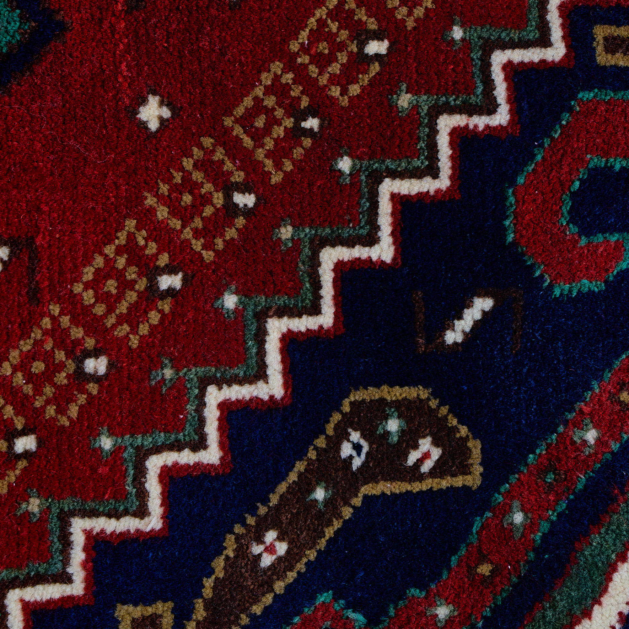 rug in deep red wool with triple diamond motif, demonstrating handwoven rug craftsmanship.
