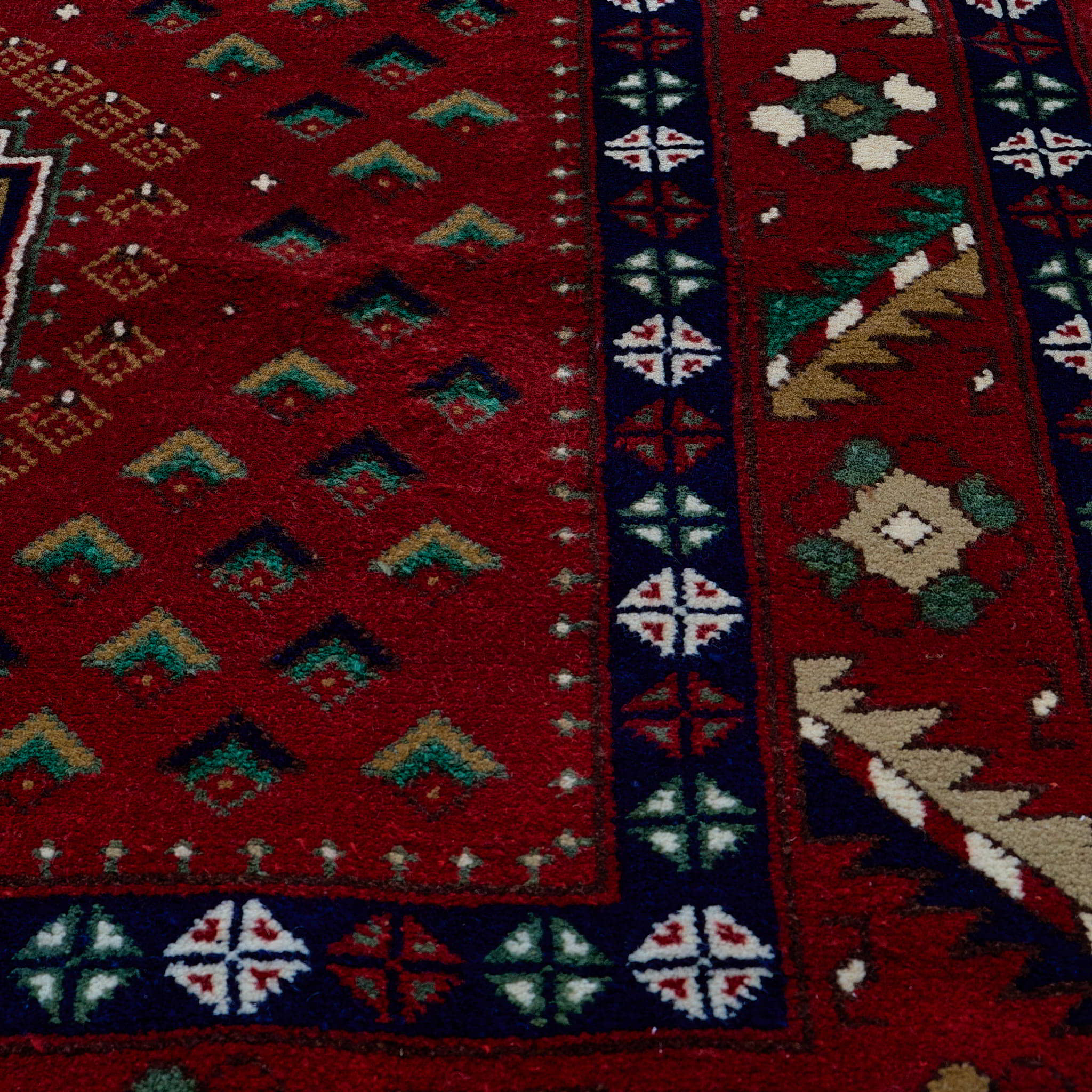 rug in deep red wool with triple diamond motif, demonstrating handwoven rug craftsmanship.