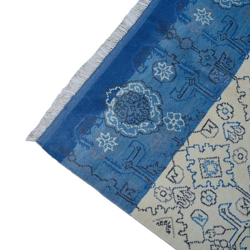 rug in beige wool with tilework/arabesque motif, demonstrating handwoven rug craftsmanship.