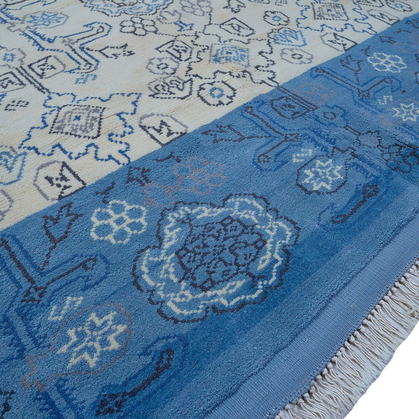 rug in beige wool with tilework/arabesque motif, demonstrating handwoven rug craftsmanship.