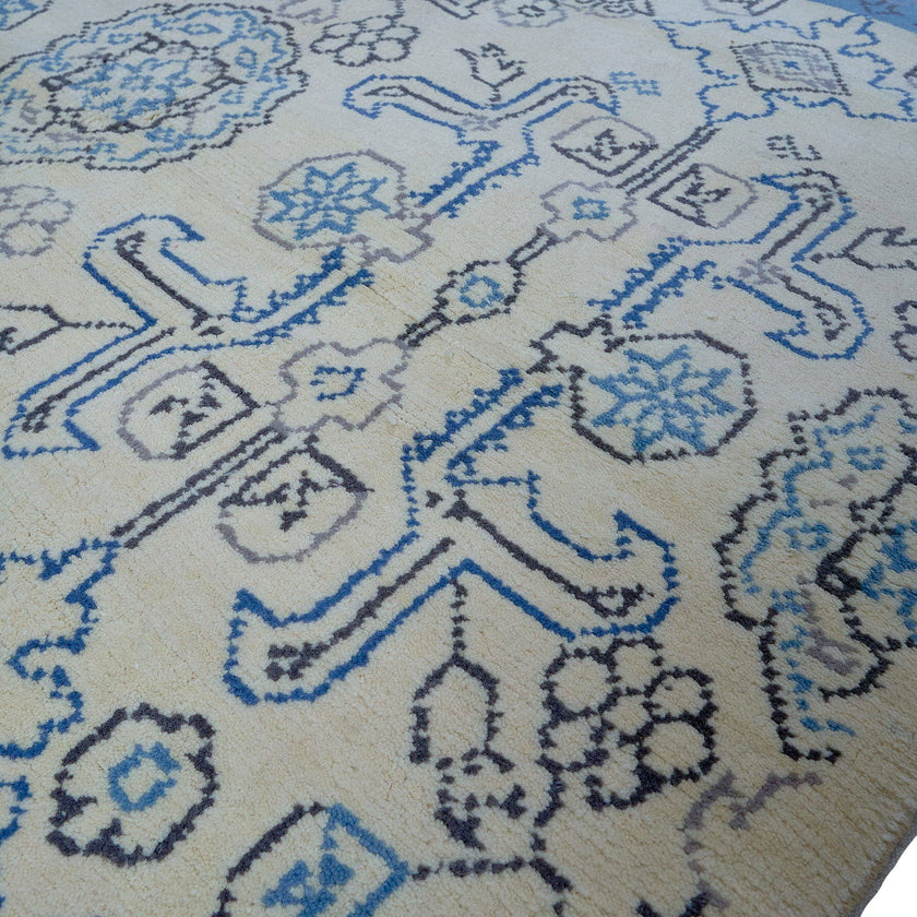 rug in beige wool with tilework/arabesque motif, demonstrating handwoven rug craftsmanship.