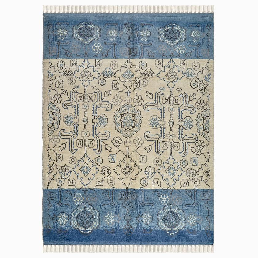 rug in beige wool with tilework/arabesque motif, demonstrating handwoven rug craftsmanship.