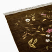rug in brown wool with vinework floral motif, demonstrating handwoven rug craftsmanship.