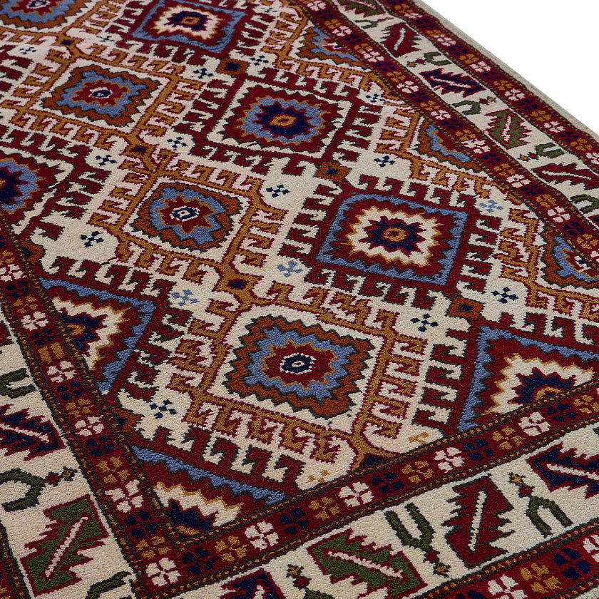 rug in red wool with geometric lattice motif, demonstrating handwoven rug craftsmanship.