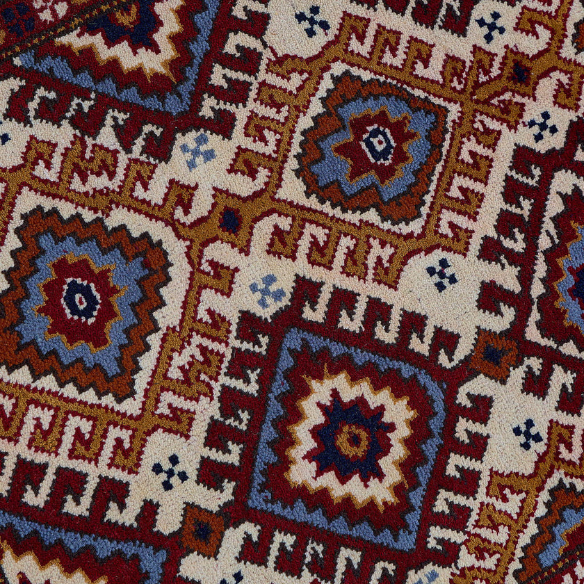 rug in red wool with geometric lattice motif, demonstrating handwoven rug craftsmanship.