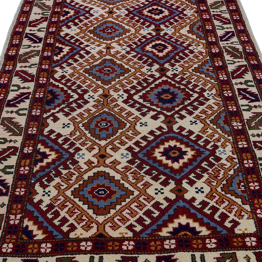 rug in red wool with geometric lattice motif, demonstrating handwoven rug craftsmanship.