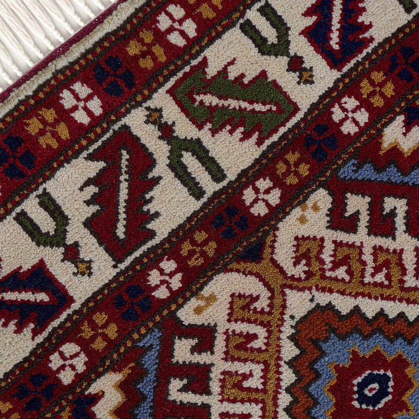 rug in red wool with geometric lattice motif, demonstrating handwoven rug craftsmanship.