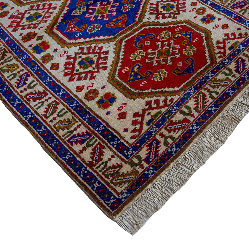 rug in deep red wool with triple medallion motif, demonstrating handwoven rug craftsmanship.