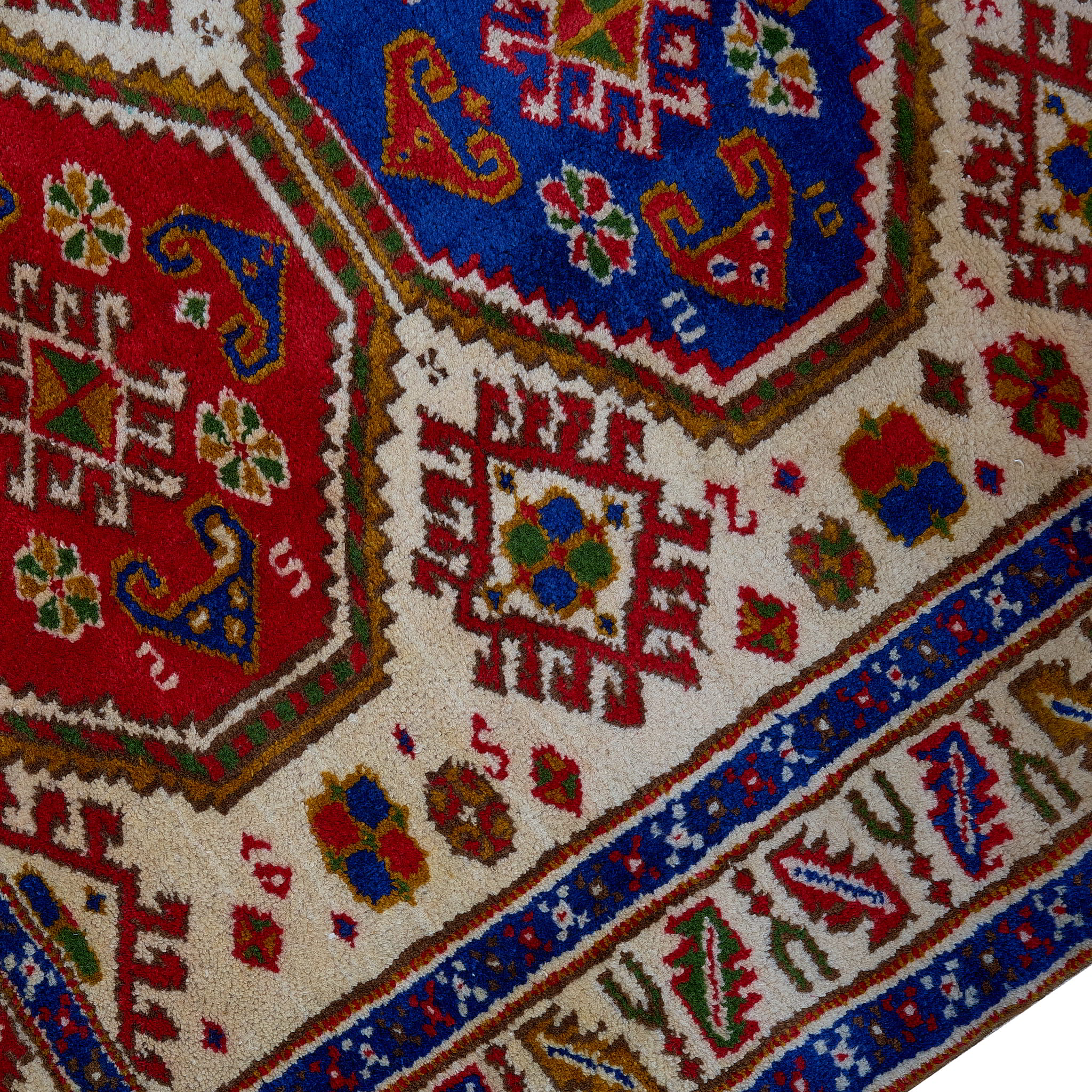 rug in deep red wool with triple medallion motif, demonstrating handwoven rug craftsmanship.