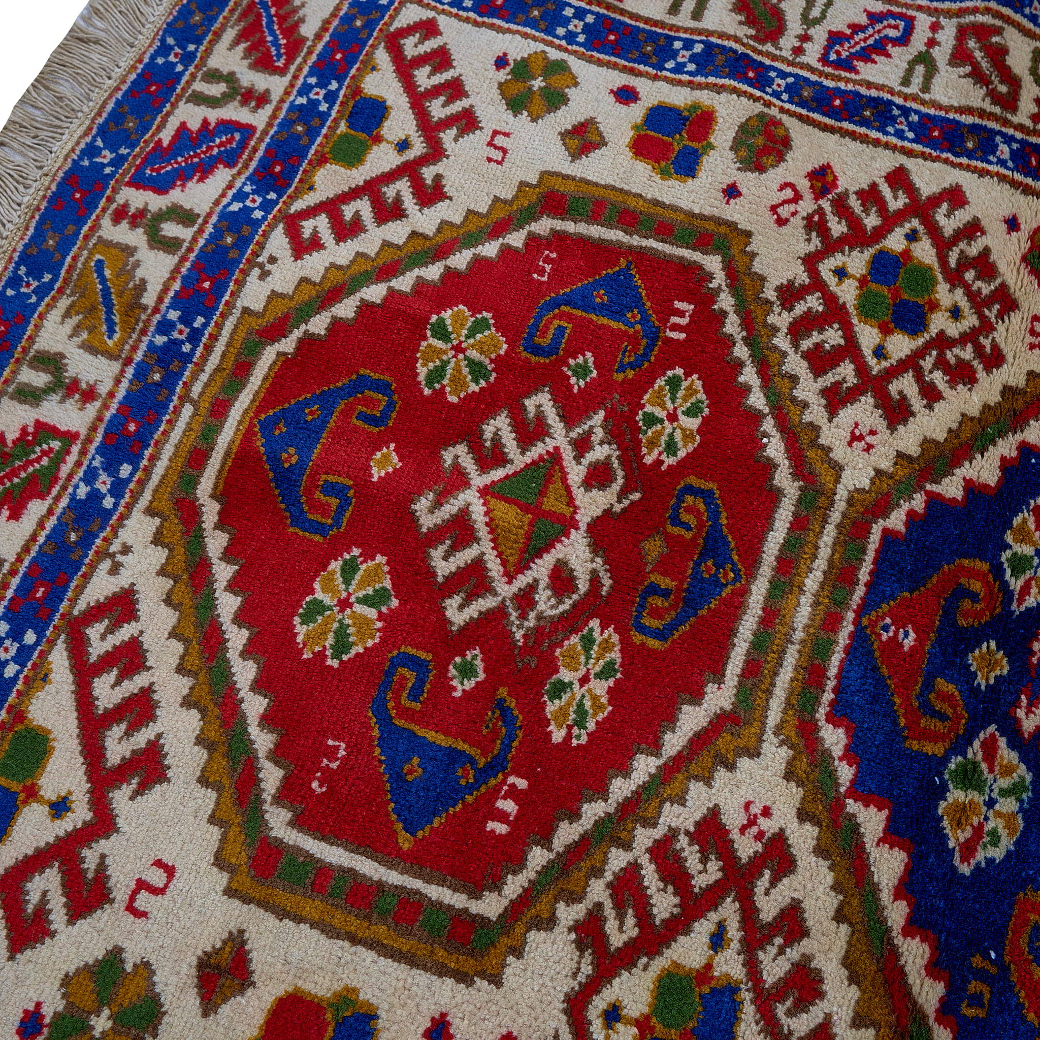 rug in deep red wool with triple medallion motif, demonstrating handwoven rug craftsmanship.