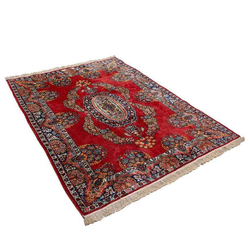 rug in deep red silk with oval floral medallion motif, demonstrating handwoven rug craftsmanship.