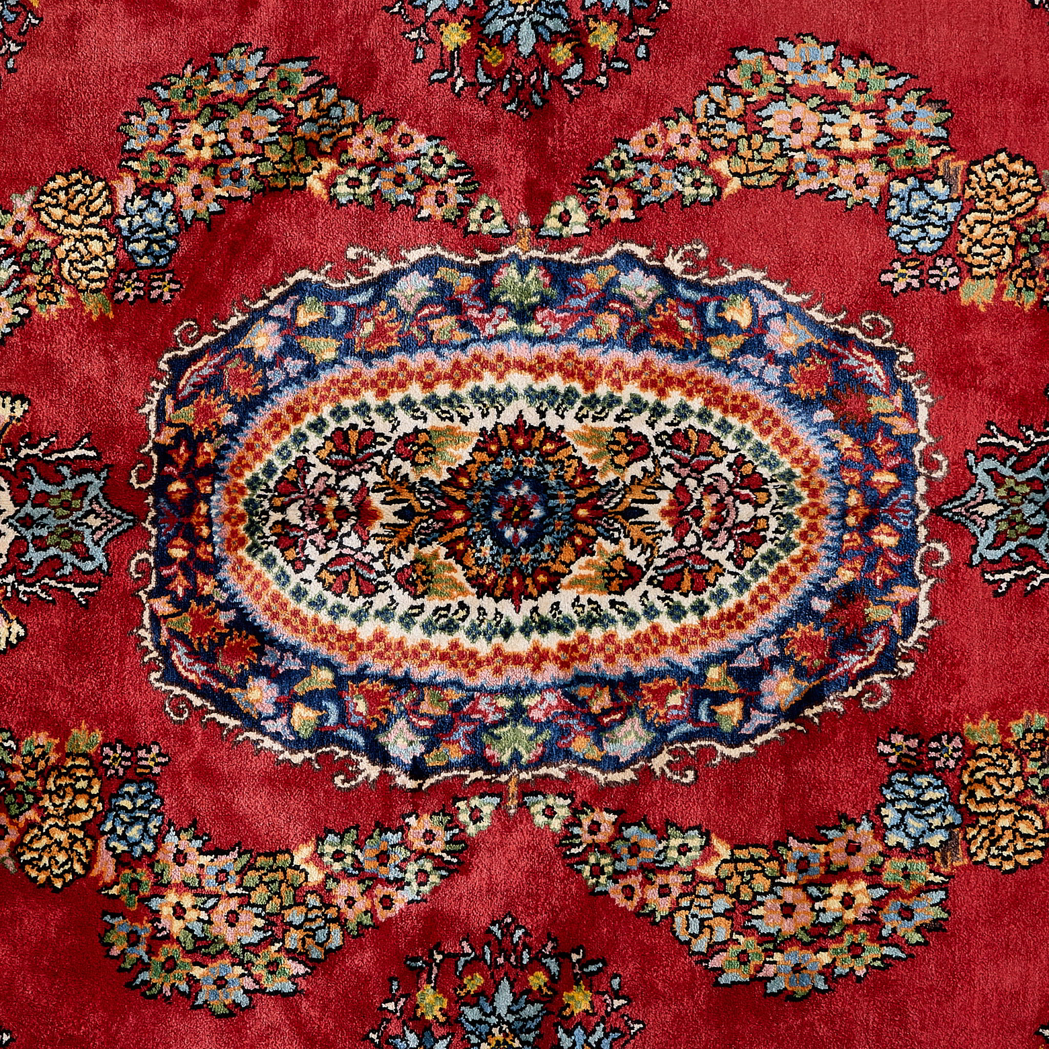 rug in deep red silk with oval floral medallion motif, demonstrating handwoven rug craftsmanship.