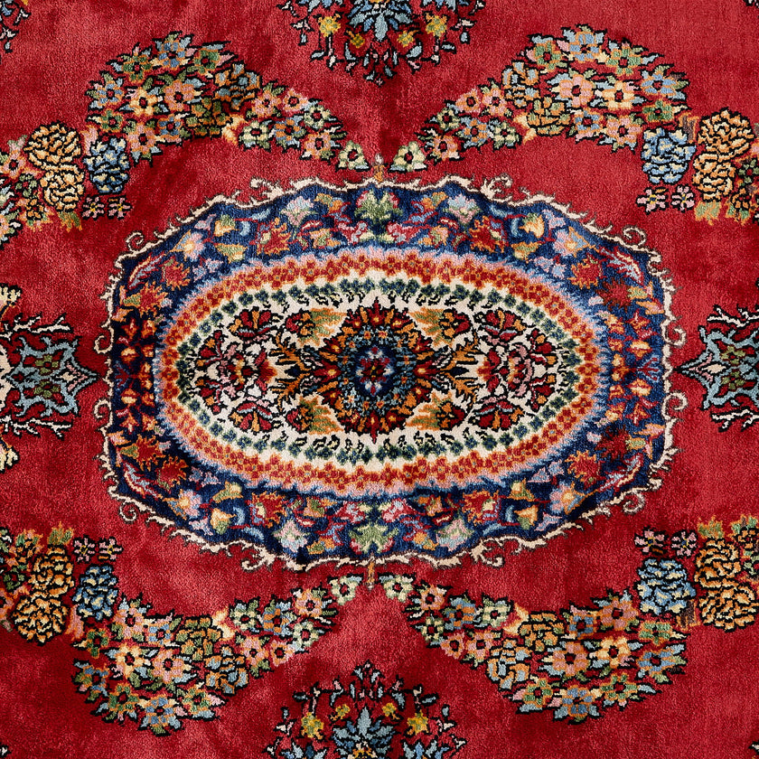 rug in deep red silk with oval floral medallion motif, demonstrating handwoven rug craftsmanship.
