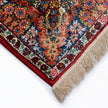 rug in deep red silk with oval floral medallion motif, demonstrating handwoven rug craftsmanship.