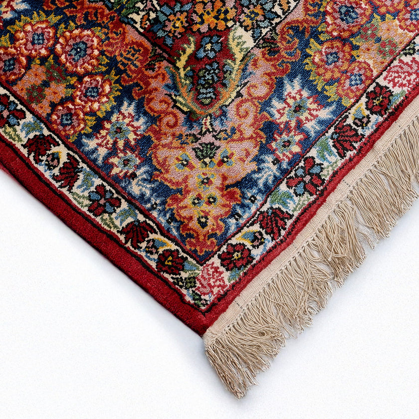 rug in deep red silk with oval floral medallion motif, demonstrating handwoven rug craftsmanship.