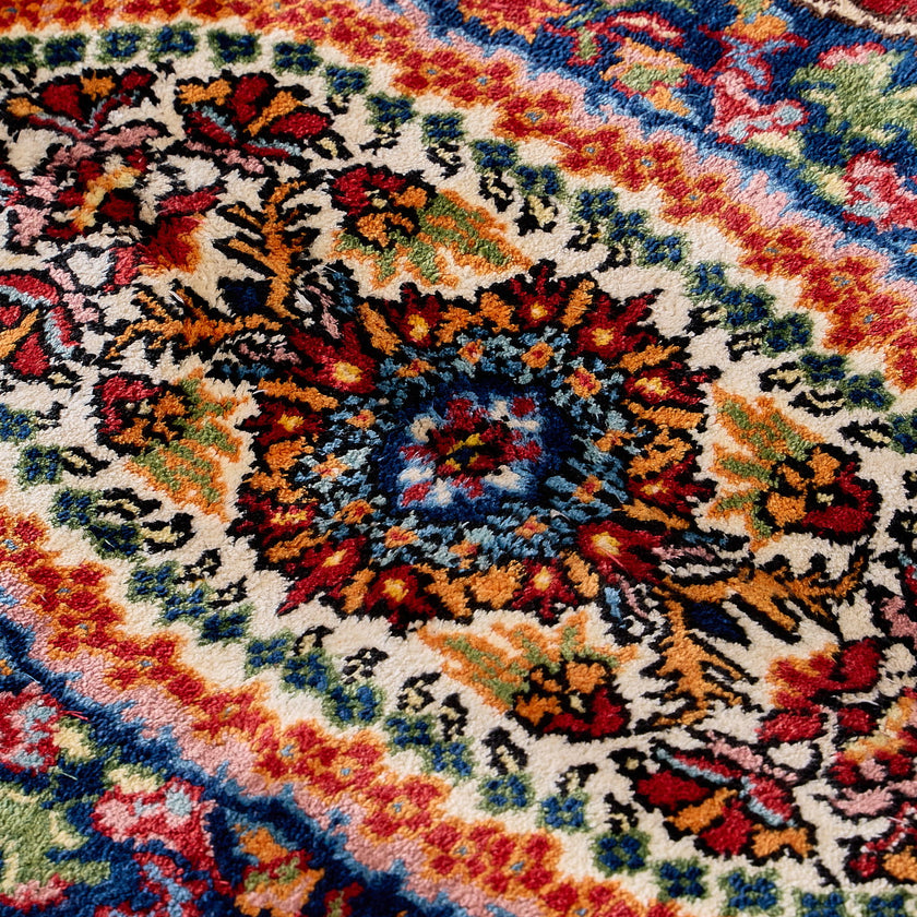 rug in deep red silk with oval floral medallion motif, demonstrating handwoven rug craftsmanship.