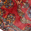 rug in deep red silk with oval floral medallion motif, demonstrating handwoven rug craftsmanship.