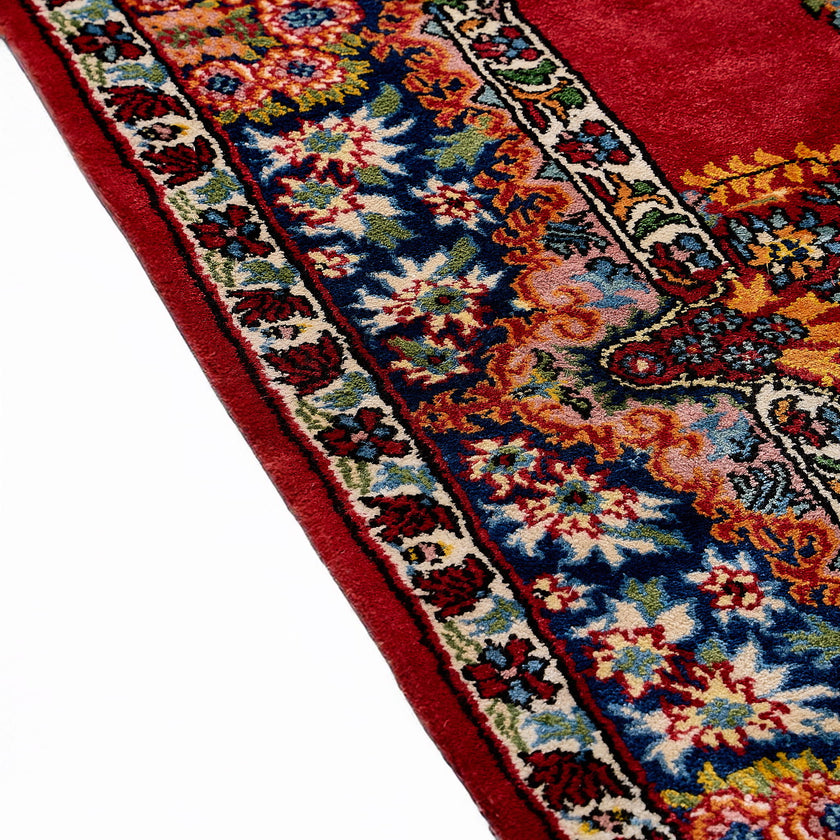 rug in deep red silk with oval floral medallion motif, demonstrating handwoven rug craftsmanship.