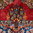 rug in deep red silk with oval floral medallion motif, demonstrating handwoven rug craftsmanship.