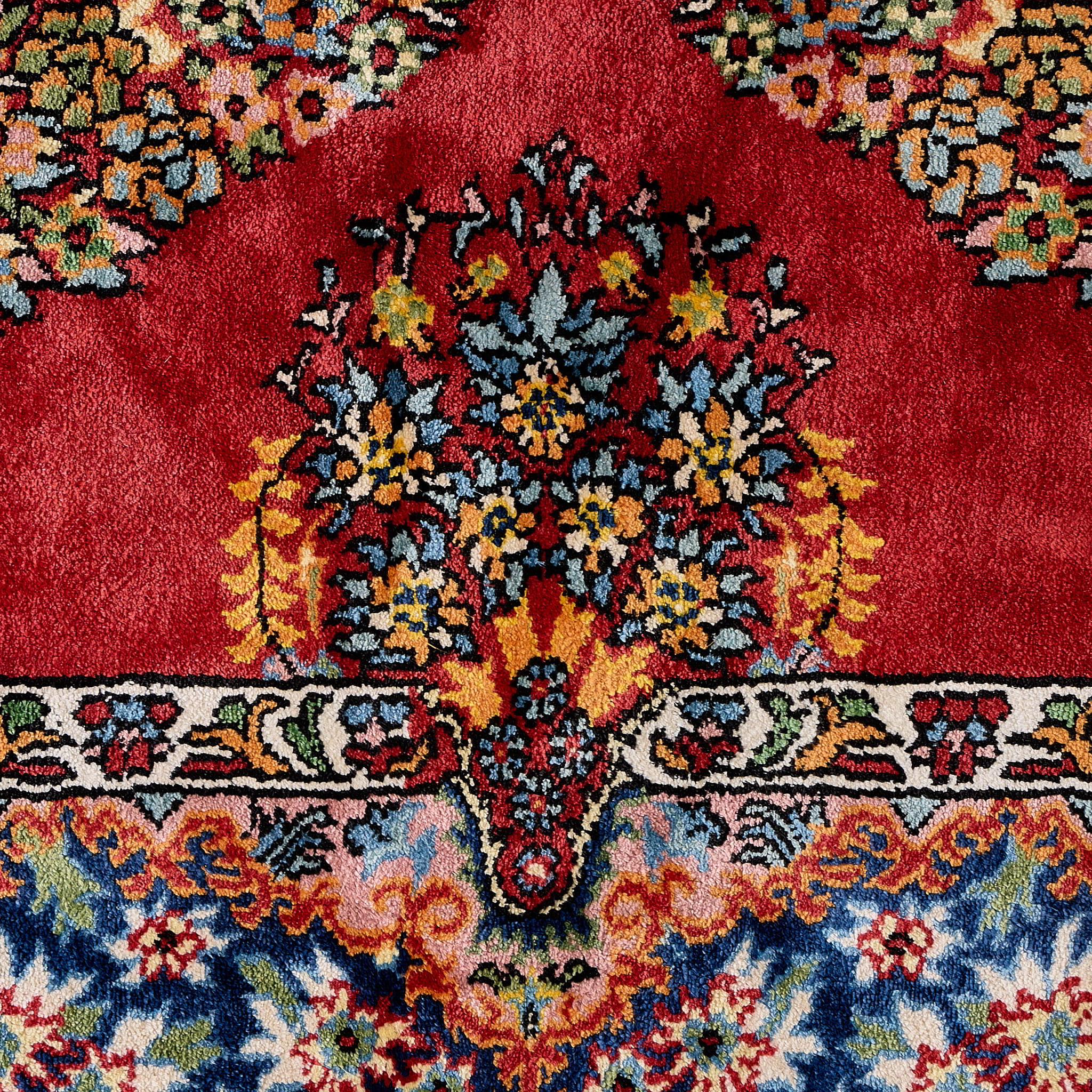 rug in deep red silk with oval floral medallion motif, demonstrating handwoven rug craftsmanship.