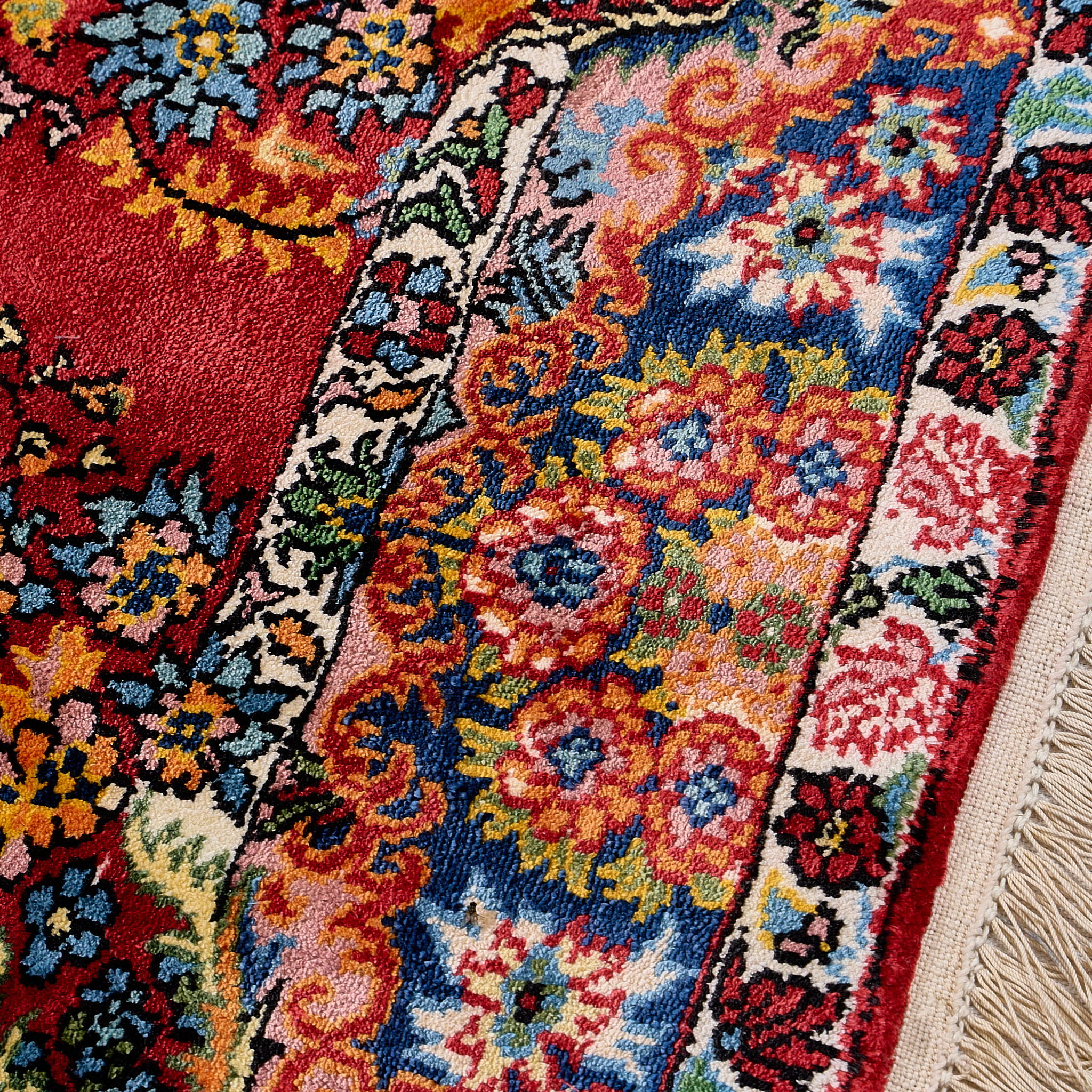rug in deep red silk with oval floral medallion motif, demonstrating handwoven rug craftsmanship.