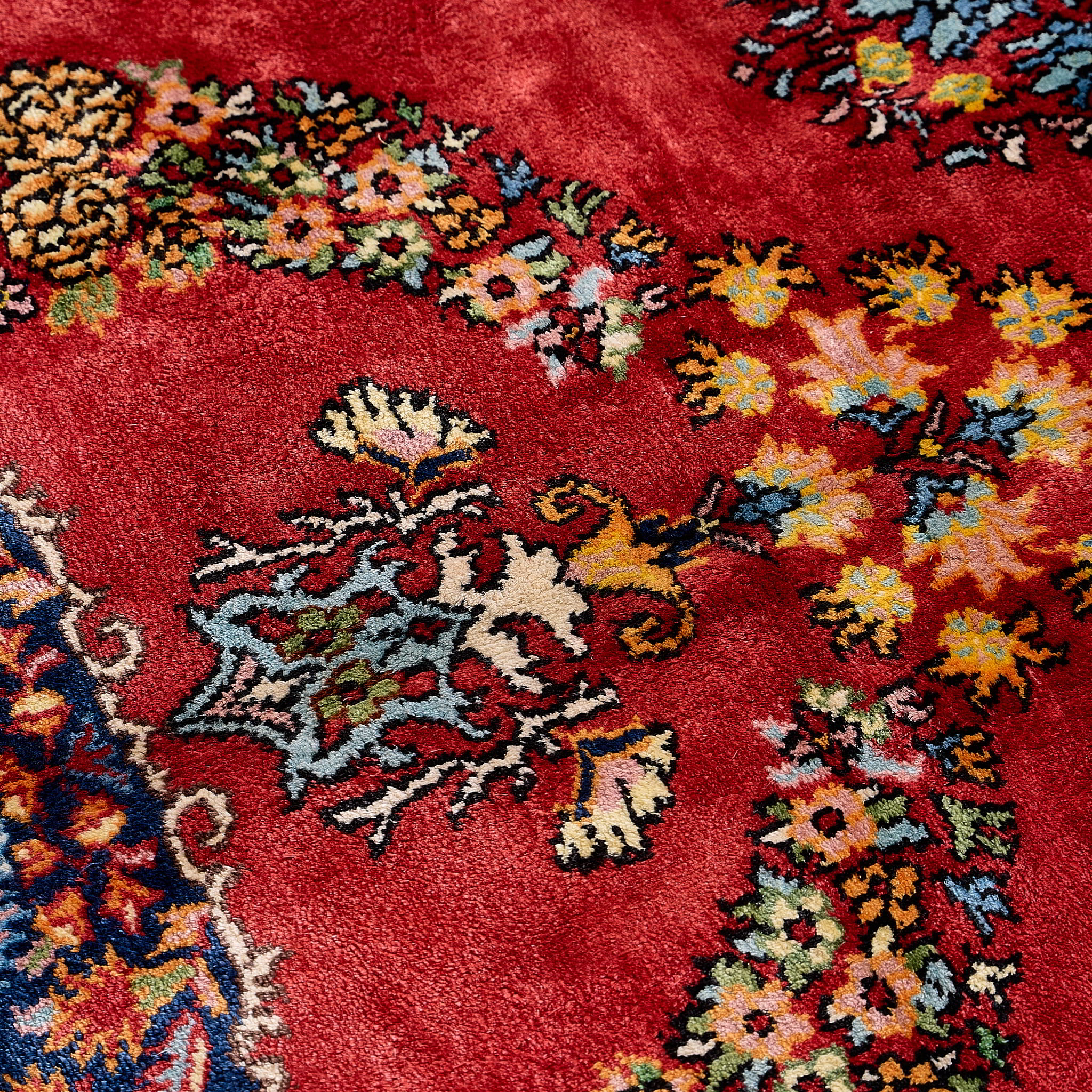 rug in deep red silk with oval floral medallion motif, demonstrating handwoven rug craftsmanship.