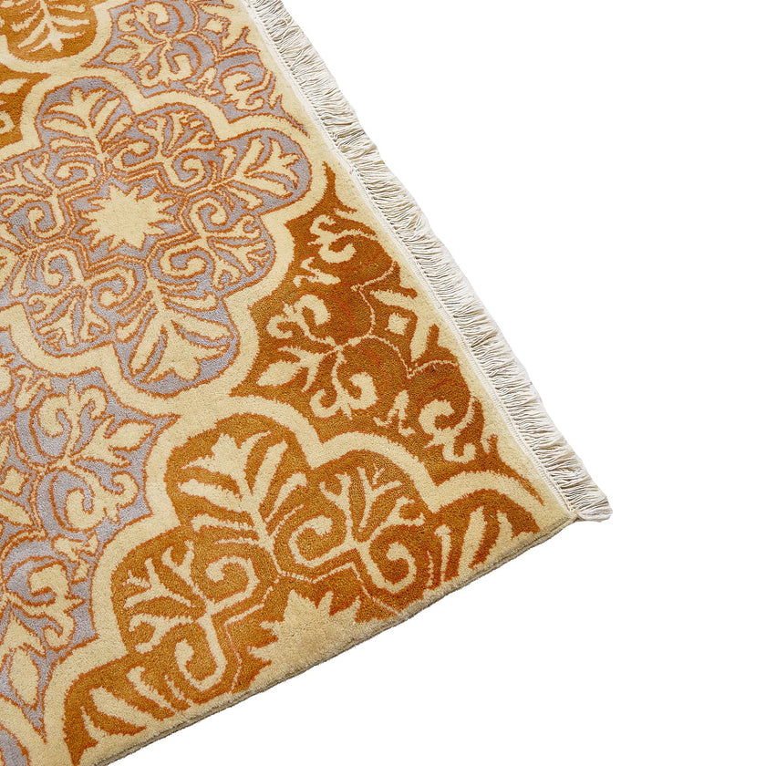 rug in lavender wool with floral/tile quatrefoil motif, demonstrating handwoven rug craftsmanship.