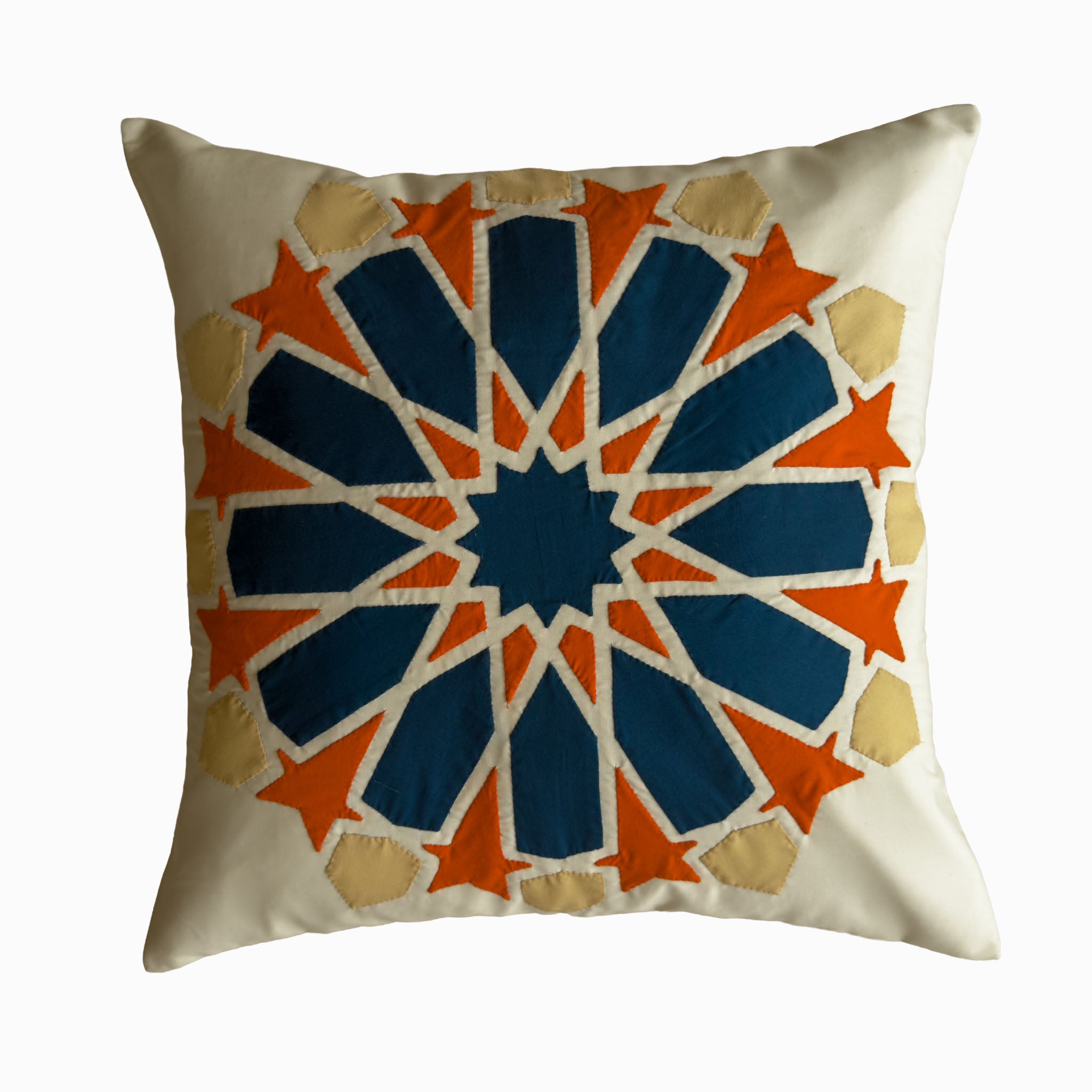 Cushion in petroleum and burnt orange polycotton with Najmi star geometry, demonstrating Khayamiya craftsmanship.