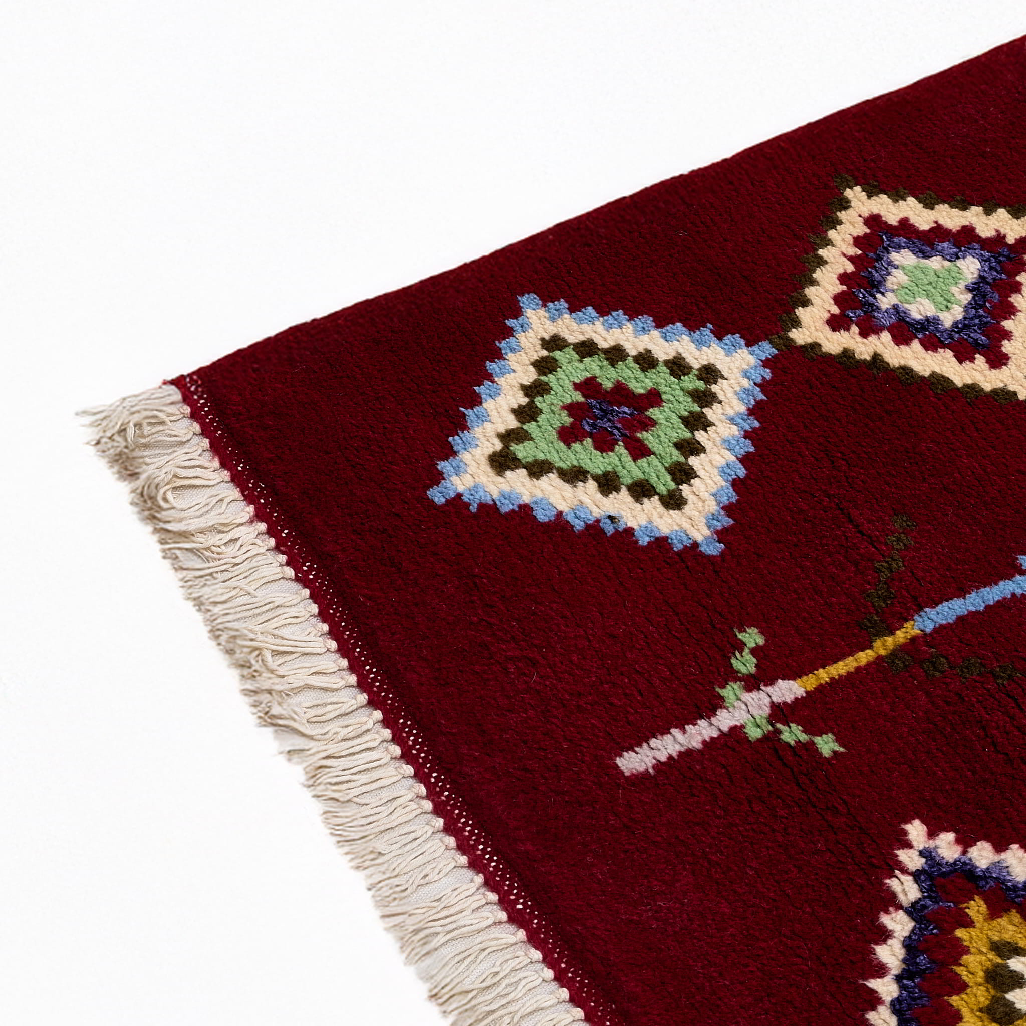 rug in deep red wool with diamond pathway motif, demonstrating handwoven rug craftsmanship.