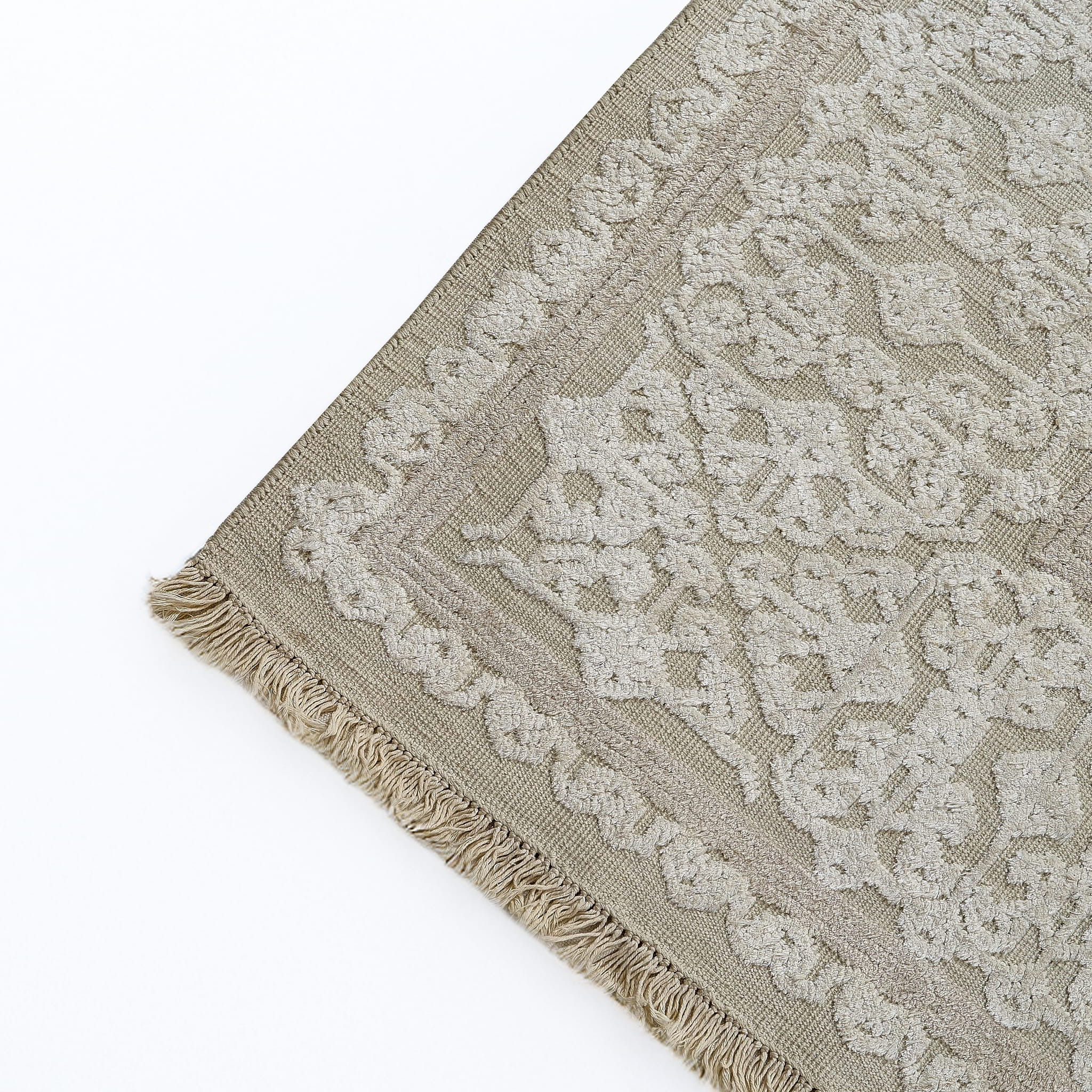 rug in beige cotton-silk blend with quiet floral field motif, demonstrating handwoven rug craftsmanship.