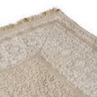 rug in beige cotton-silk blend with quiet floral field motif, demonstrating handwoven rug craftsmanship.