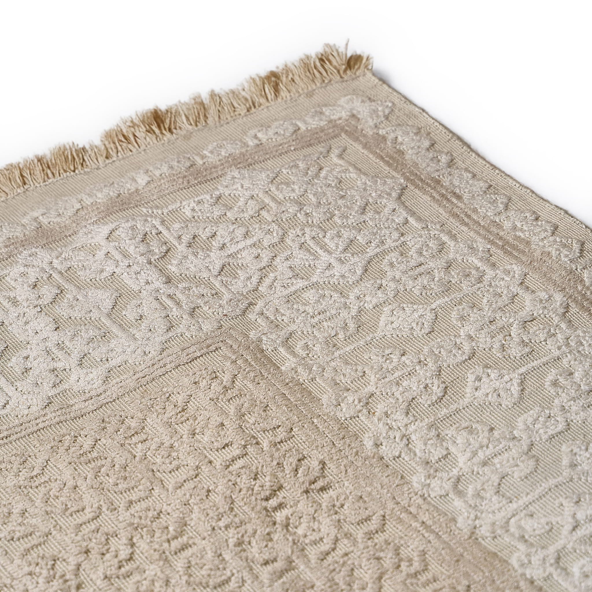 rug in beige cotton-silk blend with quiet floral field motif, demonstrating handwoven rug craftsmanship.