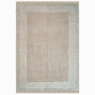 rug in beige cotton-silk blend with quiet floral field motif, demonstrating handwoven rug craftsmanship.