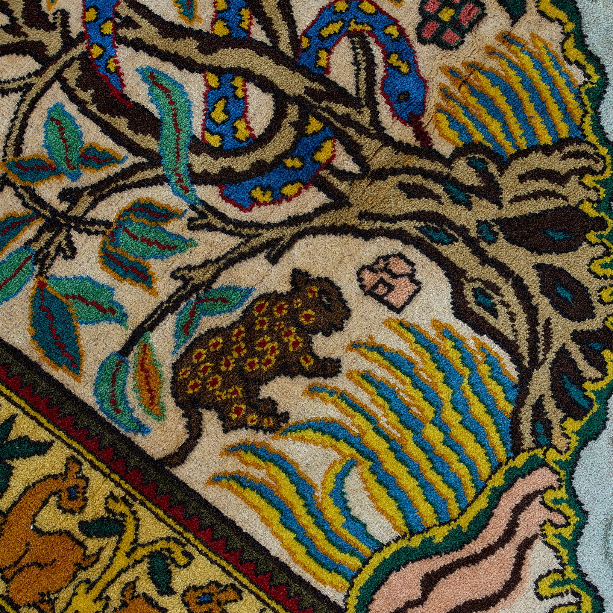 wall art in green wool with figurative village textile motif, demonstrating handwoven rug craftsmanship.