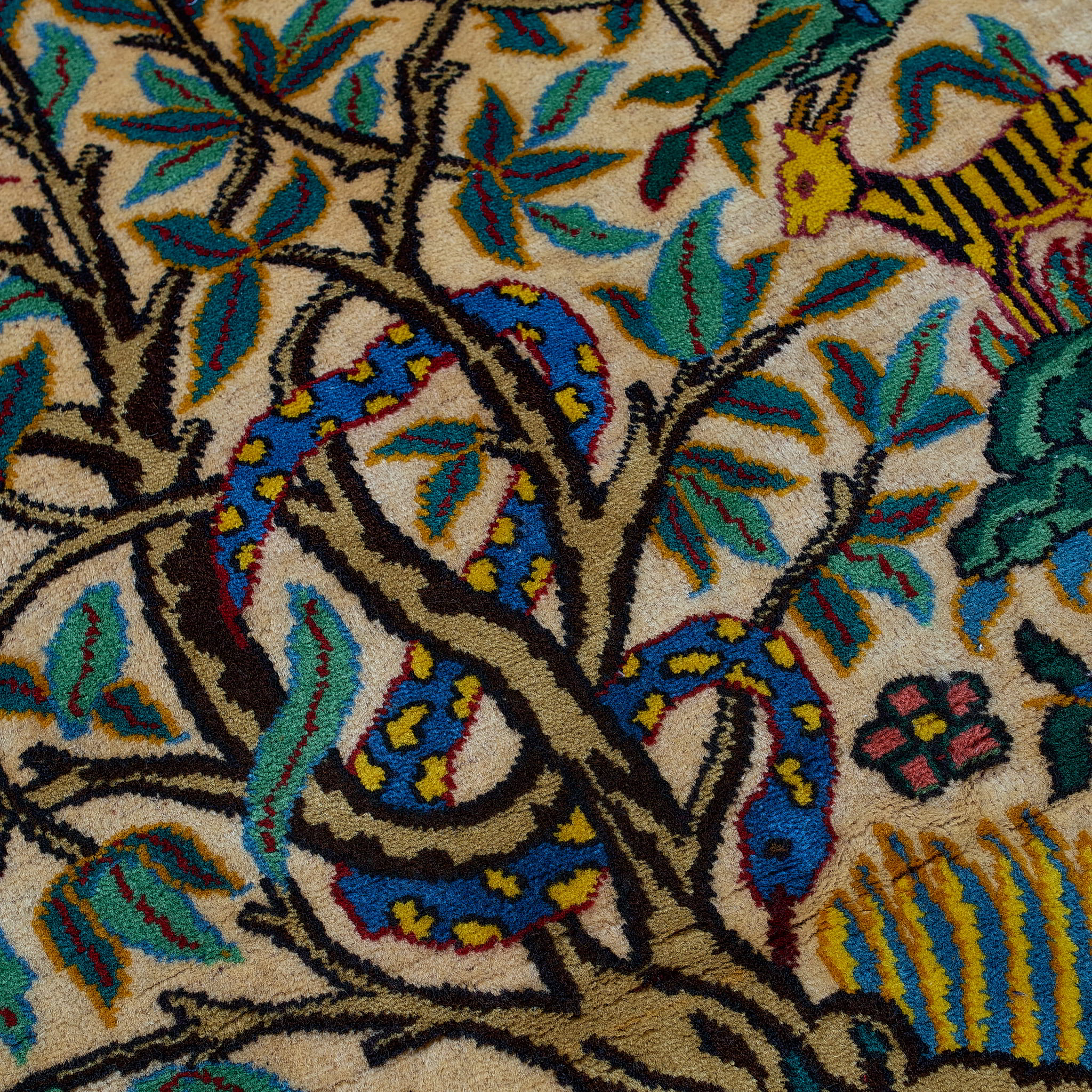 wall art in green wool with figurative village textile motif, demonstrating handwoven rug craftsmanship.