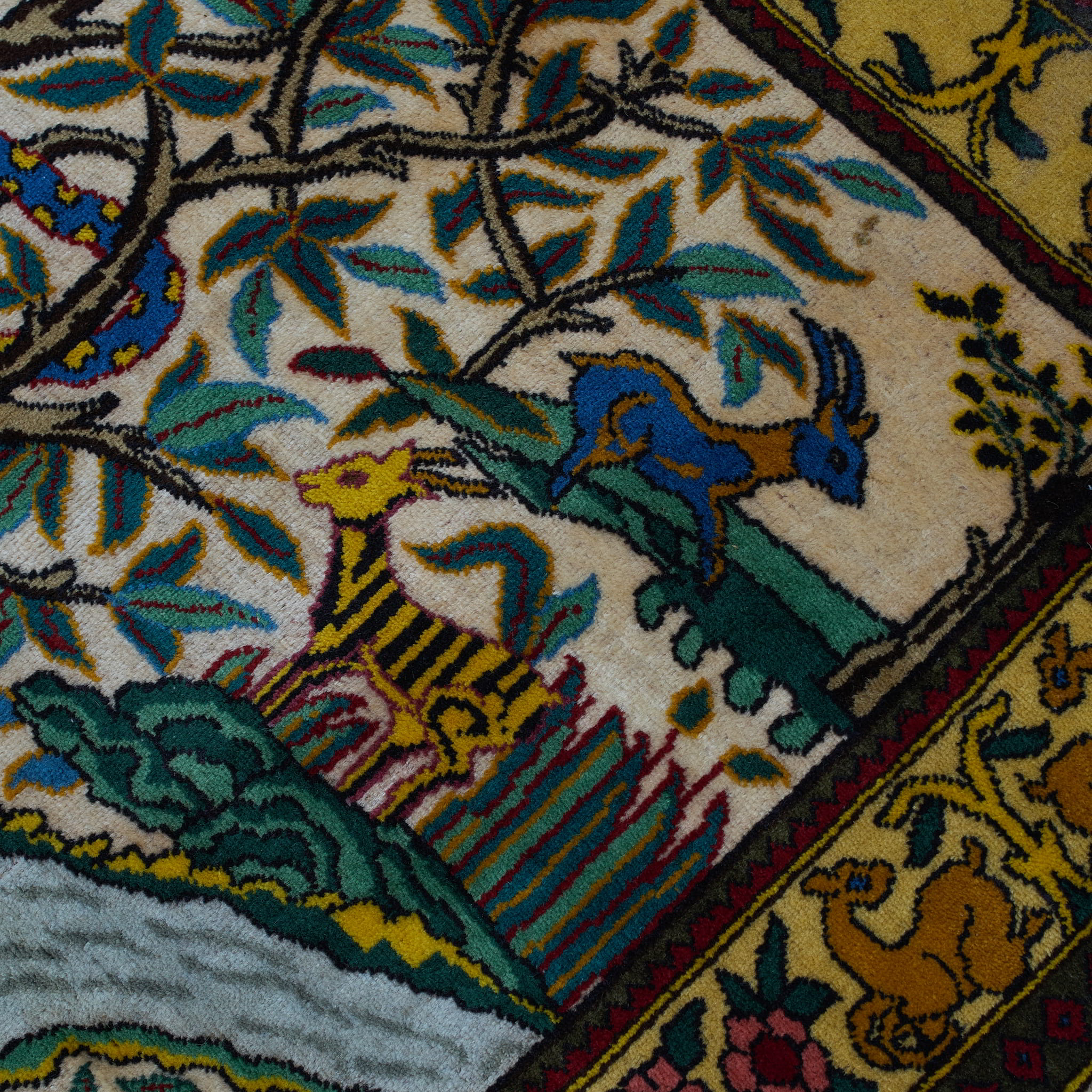 wall art in green wool with figurative village textile motif, demonstrating handwoven rug craftsmanship.