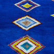 rug in vivid blue wool with tribal diamond motif, demonstrating handwoven rug craftsmanship.