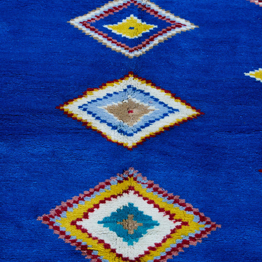 rug in vivid blue wool with tribal diamond motif, demonstrating handwoven rug craftsmanship.